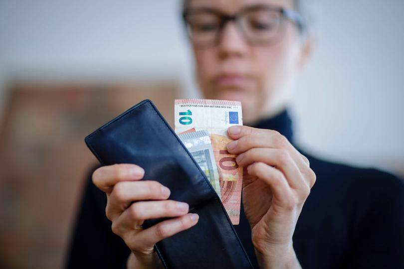 Berlin, Germany - April 06: Symbolic photograph. A woman takes bank notes from a wallet on April 06, 2020 in Berlin, Germany. (Photo by Thomas Trutschel/Photothek via Getty Images)