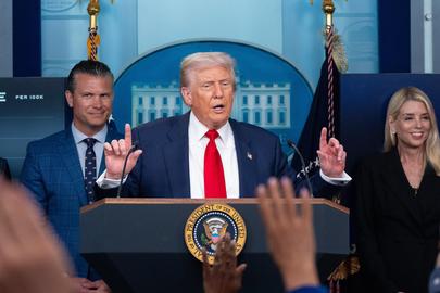President Donald Trump op zijn persconferentie, geflankeerd door defensieminister Pete Hegseth en justitieminister Pam Bondi.
