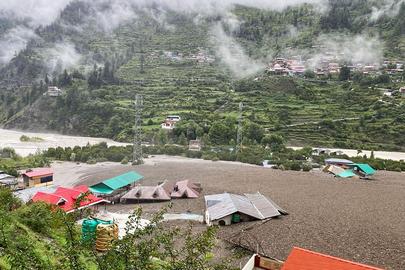 This handout photograph taken on August 5, 2025 and released by the Indian Army shows residential buildings partially submerged in sludge after a cloudburst caused a massive mudslide in India's Uttarakhand state. A flash flood driving a torrent of mud smashed into a town in India's Himalayan region on August 5, tearing down a mountain valley before demolishing buildings and killing at least four people. (Photo by Indian Army / AFP) / RESTRICTED TO EDITORIAL USE - MANDATORY CREDIT "AFP PHOTO / Indian Army / - " - HANDOUT - NO MARKETING NO ADVERTISING CAMPAIGNS - DISTRIBUTED AS A SERVICE TO CLIENTS