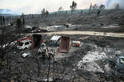 This photograph shows burnt vehicles in an area devastated by a wildfire near Fontjoncouse, southwestern France, on August 6, 2025. A wildfire has killed one person and injured nine others, scorching 11,000 hectares as firefighters work to contain the blaze, local officials said. The fire, which started the day before, has destroyed or damaged 25 homes in the southern Aude department, where more than 1,800 firefighters have been battling to control what is now the largest wildfire in France this summer. (Photo by Lionel BONAVENTURE / AFP)